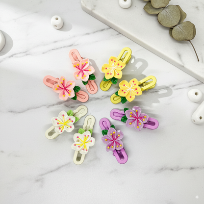 Set of colorful floral hair clips on a marble surface