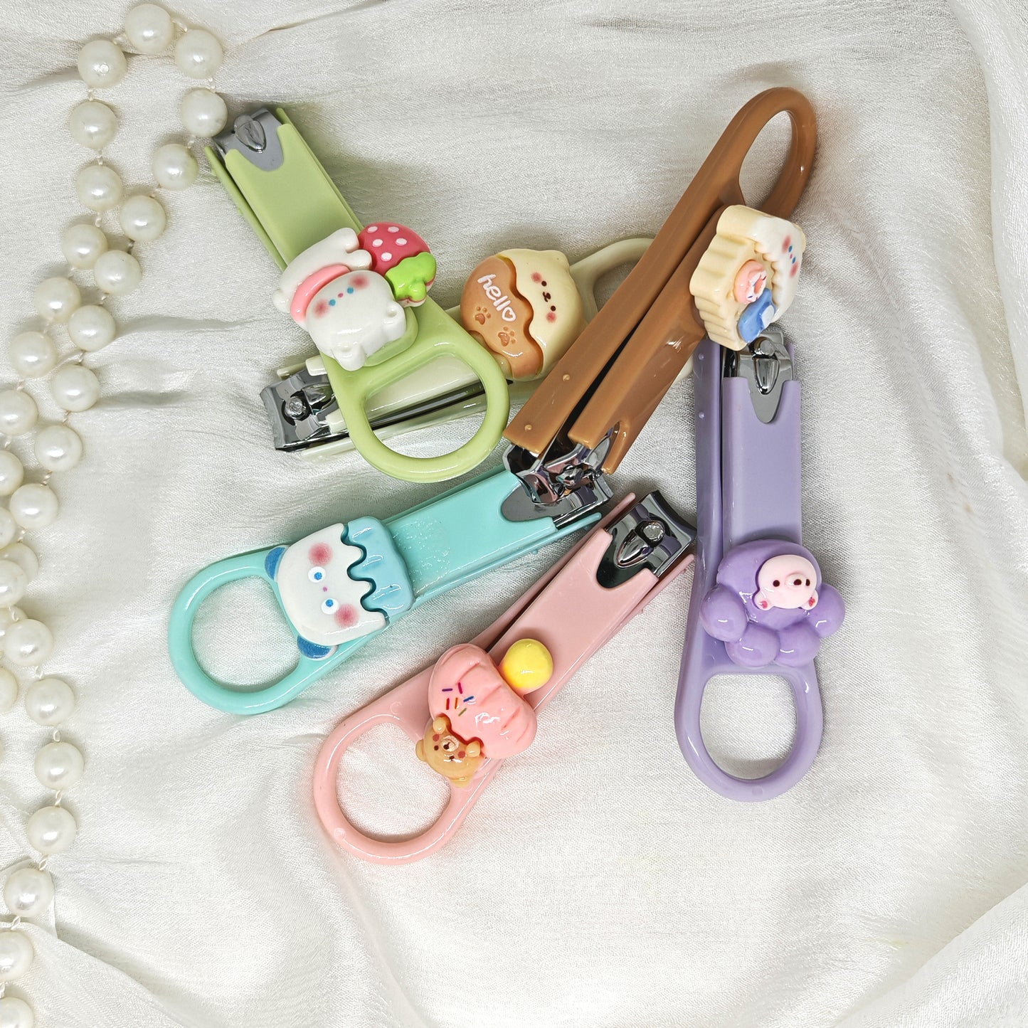 Set of colorful nail clippers with cartoon character handles on a white background