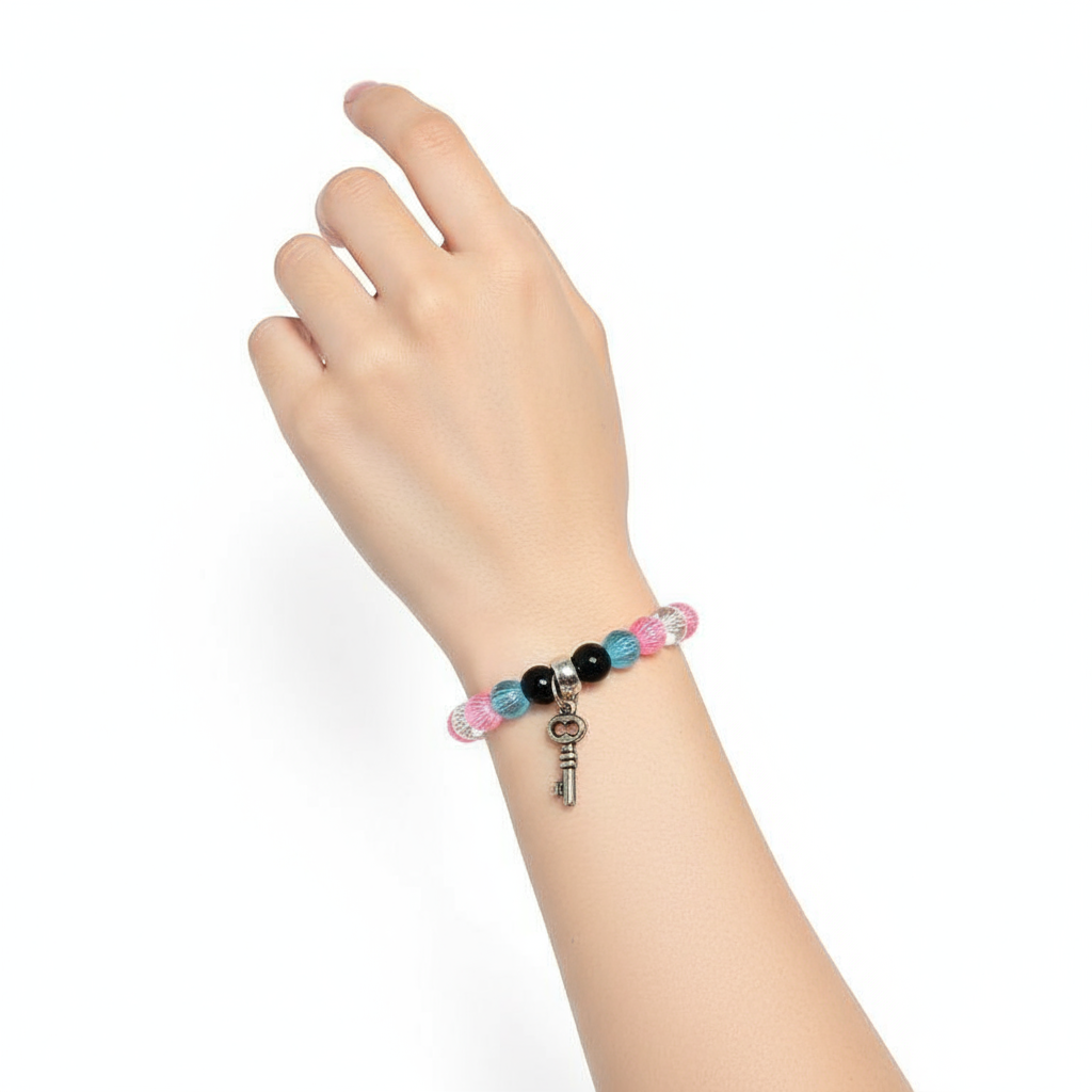 Colorful Bracelet with key-shaped charm on a white background in hand